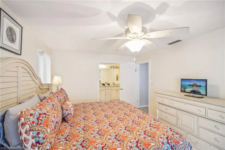 Bedroom with ceiling fan and connected bathroom