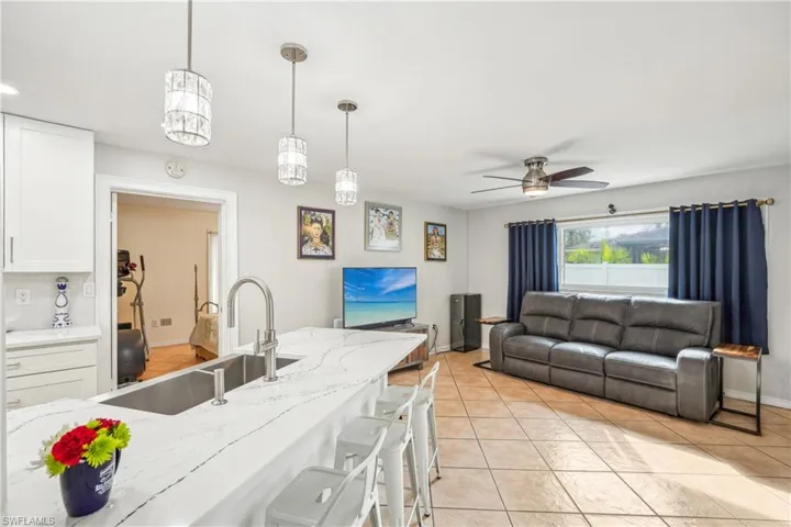 Kitchen with white cabinets, ceiling fan, sink, and hanging light fixtures