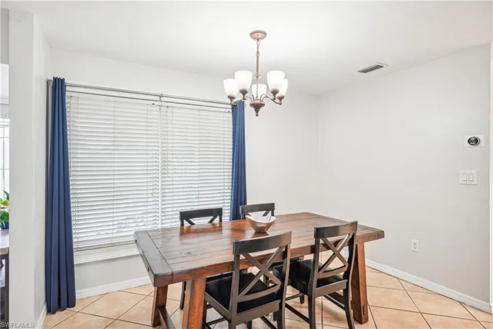 Tiled dining space featuring a chandelier