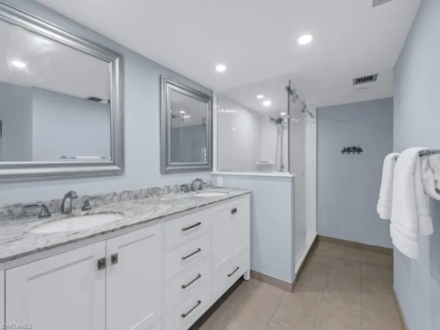 Bathroom with tile patterned flooring, vanity, and walk in shower