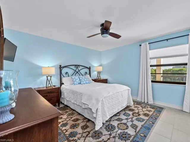 Bedroom with ceiling fan and light tile patterned flooring