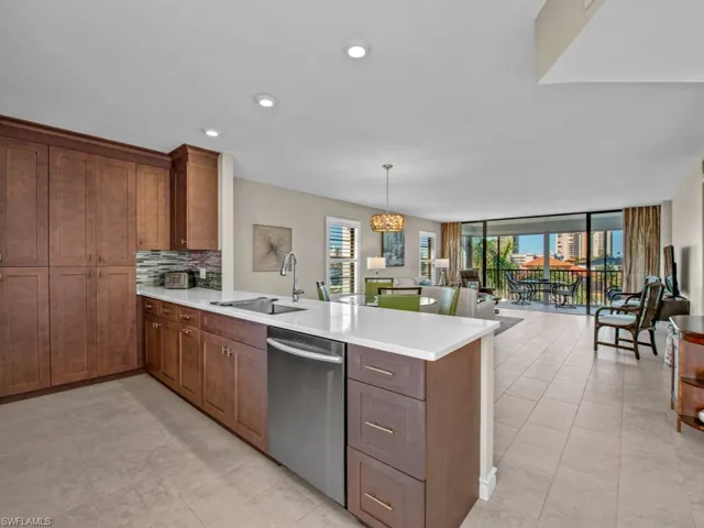 Kitchen featuring dishwasher, backsplash, sink, hanging light fixtures, and kitchen peninsula