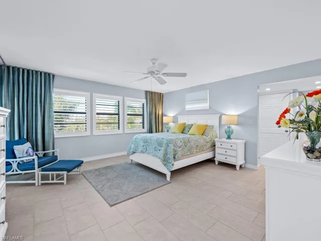 Bedroom with ceiling fan and light tile patterned flooring