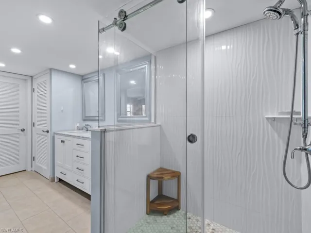 Bathroom with tile patterned flooring, vanity, and walk in shower