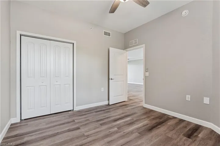 Unfurnished bedroom with LVP flooring, a closet, and ceiling fan