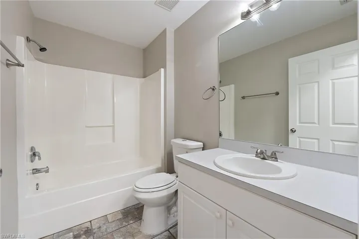 Full bath with tile patterned flooring, crown molding, and double walk-in shower