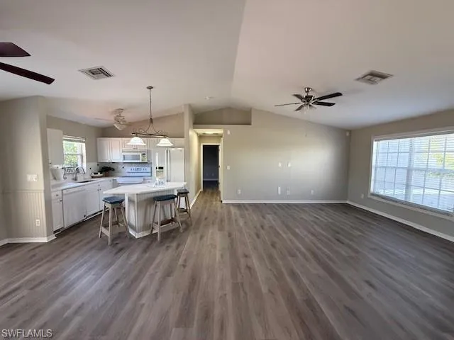 Kitchen with white appliances, a sink, light countertops, french doors, and ceiling fan
