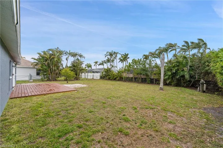 Rear view of property featuring a deck, expansive lawn and French doors, plenty of room for garden, pool or out door entertaining