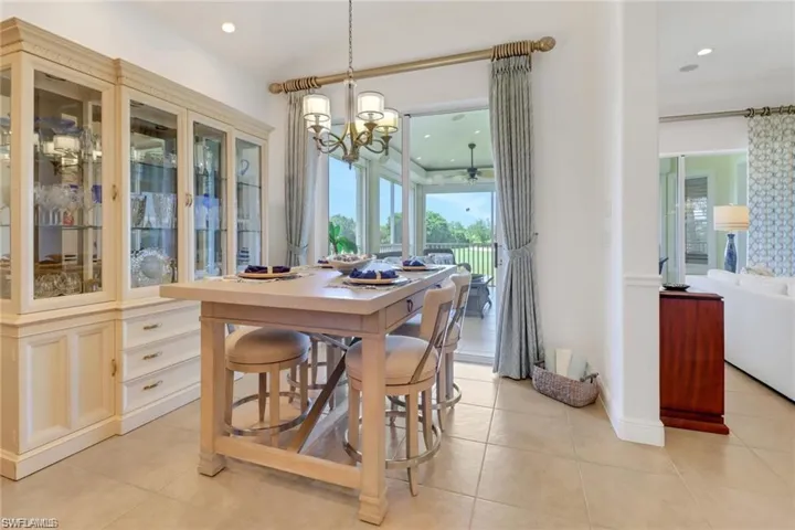 Tiled dining room featuring an inviting chandelier