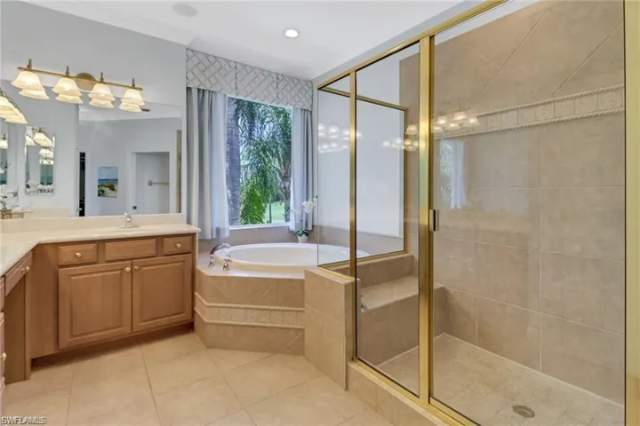 Bathroom with plus walk in shower, tile patterned flooring, and vanity