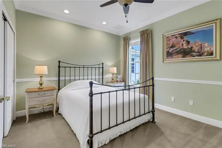 Carpeted bedroom featuring ceiling fan, a closet, and ornamental molding
