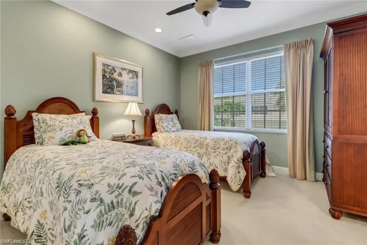 Carpeted bedroom featuring ceiling fan