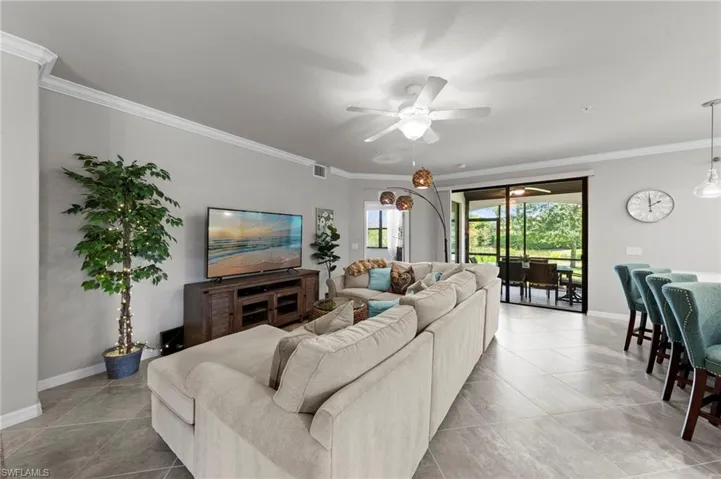 Tiled living area featuring crown molding