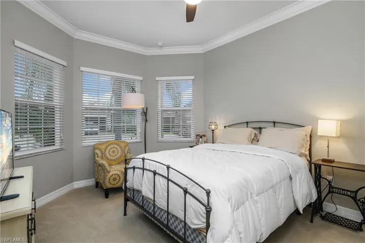 Bedroom featuring carpet flooring, ceiling fan, and crown molding