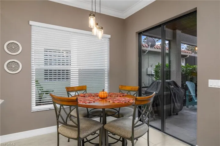 Dining area featuring a healthy amount of sunlight, crown molding, and light tile patterned flooring