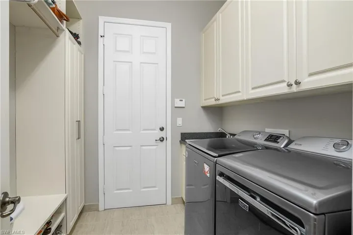 Laundry area featuring cabinets and washing machine and clothes dryer