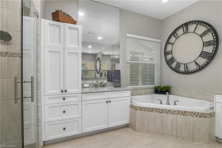 Bathroom with vanity, tile patterned floors, and plus walk in shower