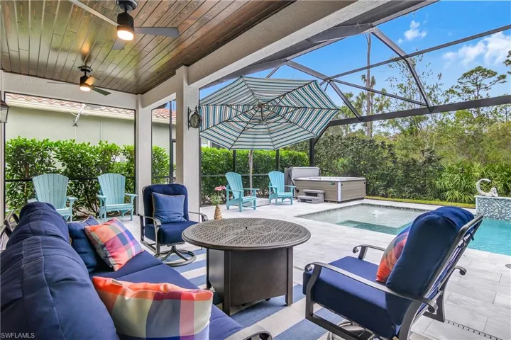 View of patio / terrace featuring a pool with hot tub, glass enclosure, outdoor lounge area, and ceiling fan