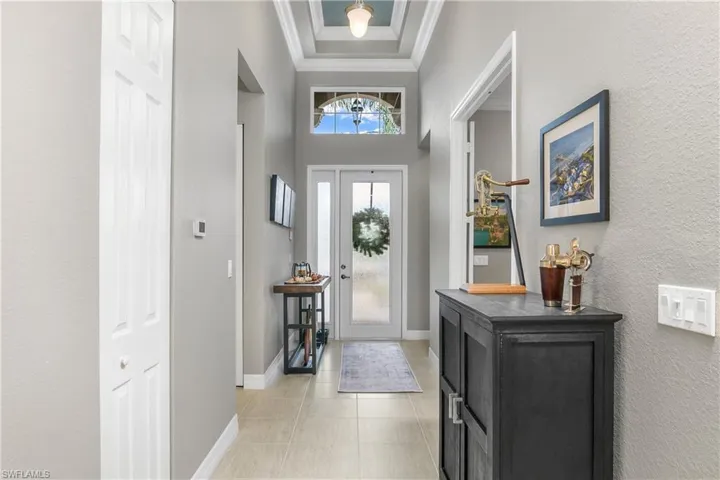 Entryway with a towering ceiling and crown molding