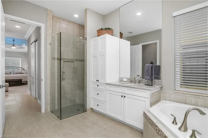 Bathroom with vanity, ceiling fan, tile patterned floors, and independent shower and bath