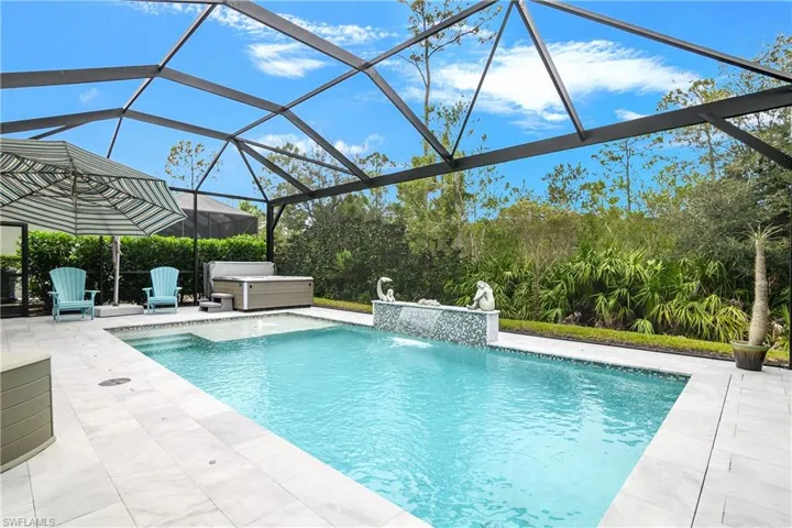 View of swimming pool with a lanai, pool water feature, and a patio