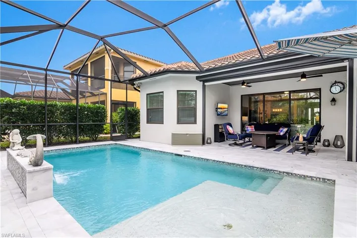 View of swimming pool featuring glass enclosure, a patio area, and ceiling fan
