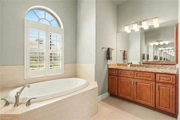 Full bathroom featuring plenty of natural light, vanity, and a large soaking tub