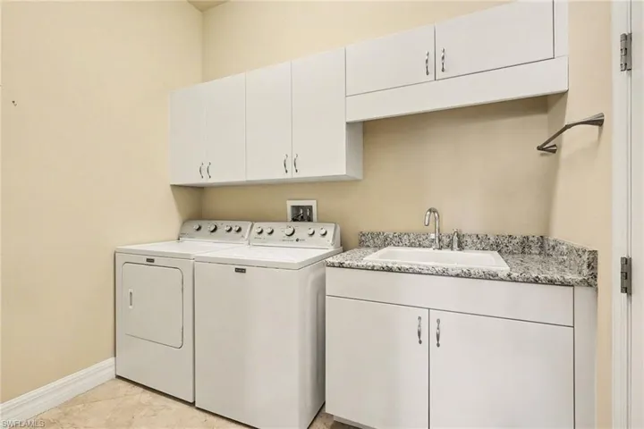 Laundry area with cabinet space and washer & dryer plus a laundry sink.