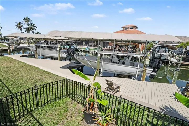 Dock area featuring boat lifts, a water view, and a separate fenced area for your furry friends.