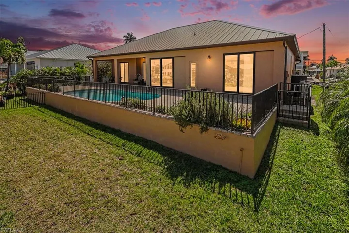 Back of property at dusk featuring a patio, a metal roof, and stucco siding.  Sunsets and sunrises are waiting for you!