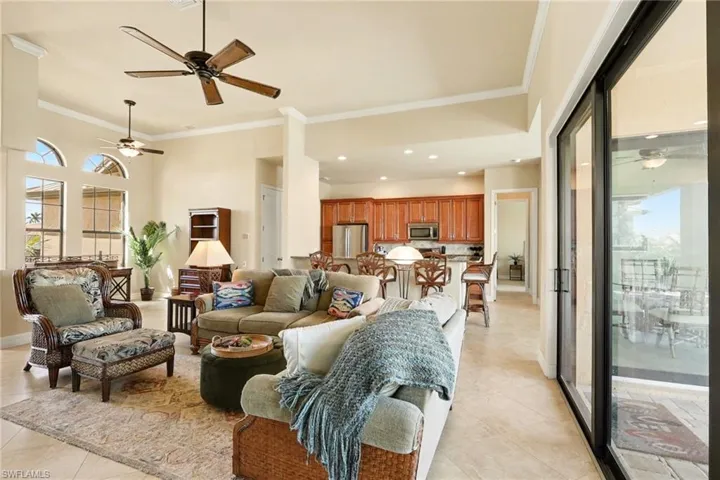 Living area featuring a ceiling fans, crown molding, recessed lighting, and a high ceilings.