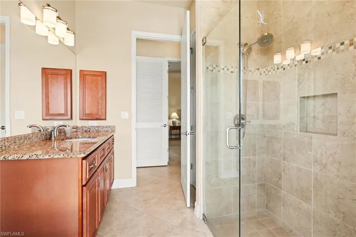 Bathroom featuring vanity and a stall shower located just off the pool.