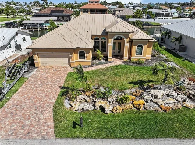 View of front of house with stucco siding, decorative driveway, an attached garage, and french doors.  Has ample room for trailer storage to the side of the driveway.