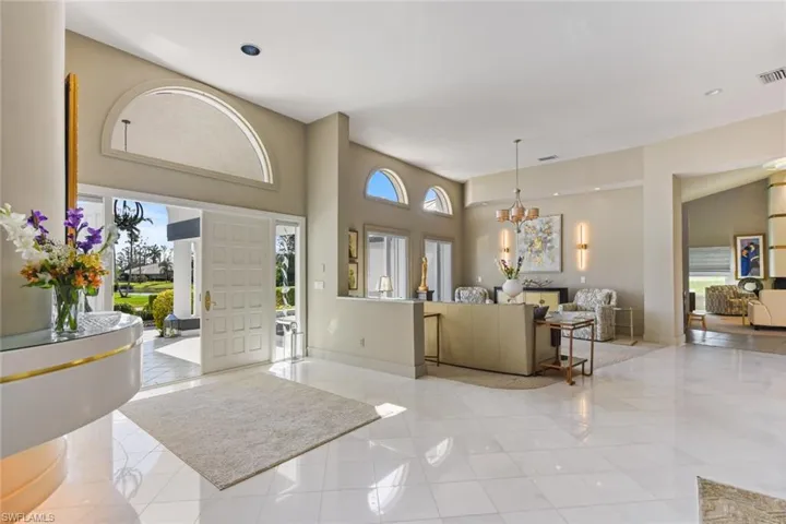 Inviting foyer features marble flooring and neutral color scheme.