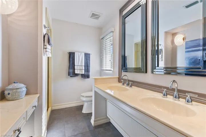 Bathroom with tile flooring, double vanity, and walk-in shower