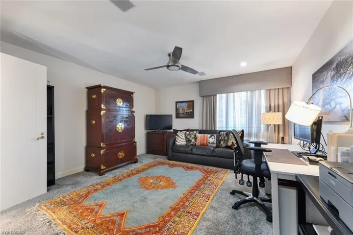 Guest bedroom with walk-in closet, full bath, lighted ceiling fan, carpet