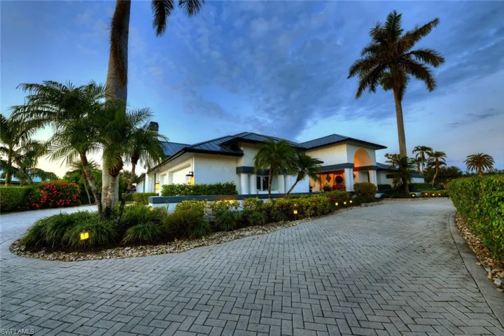 View of front of property with paver drive and 3-car garage.