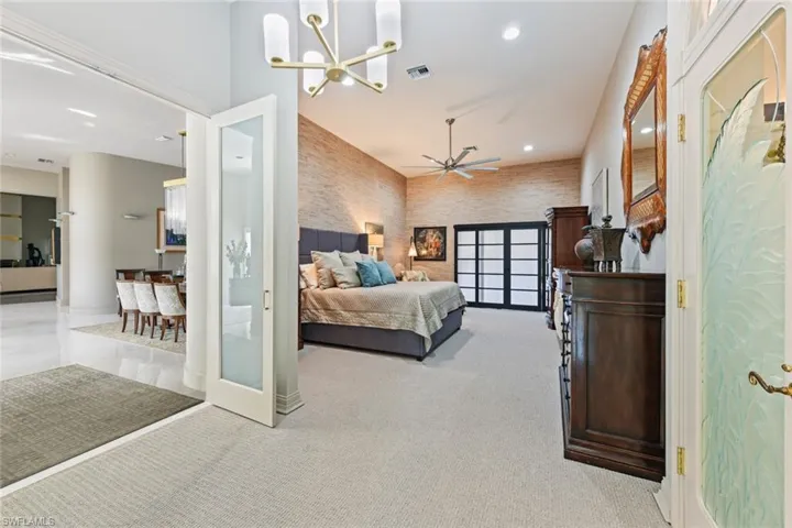 Owner's suite featuring custom glass french doors and an inviting chandelier