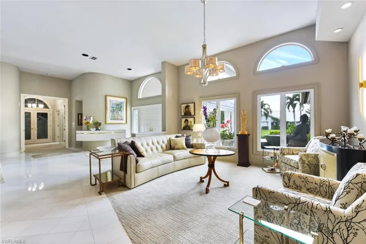Living room with newer carpet and a high ceiling and a notable chandelier