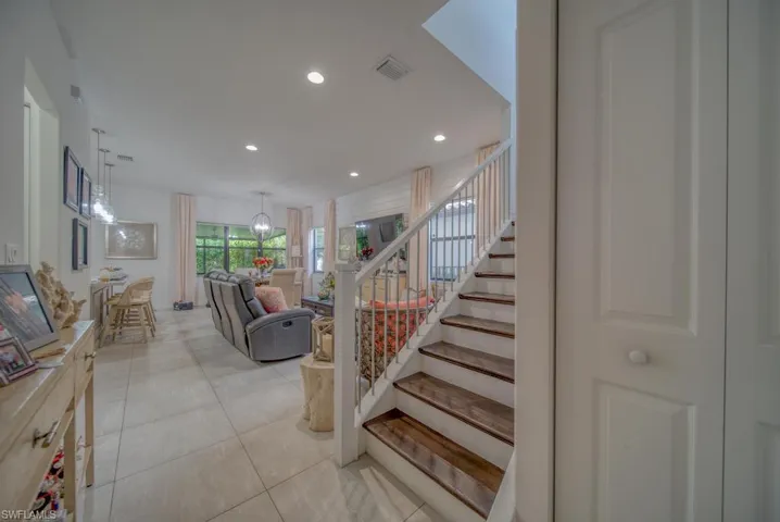 Stairs with tile patterned flooring and a chandelier