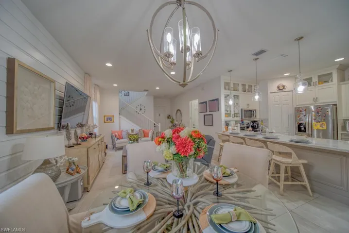 Dining space featuring recessed lighting, visible vents, light tile patterned flooring, a chandelier, and stairs
