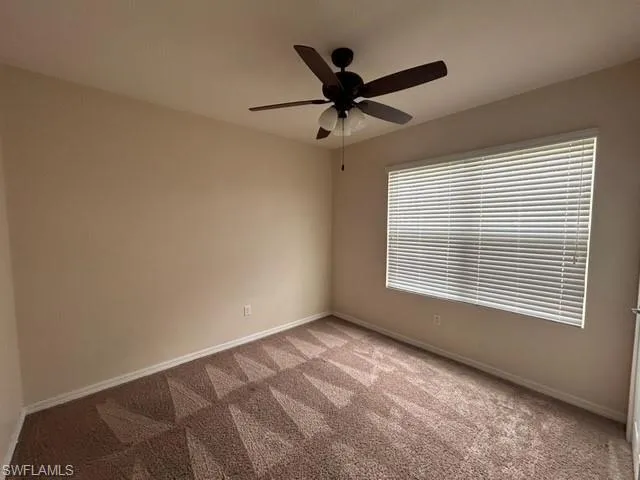 Unfurnished room featuring light colored carpet and ceiling fan