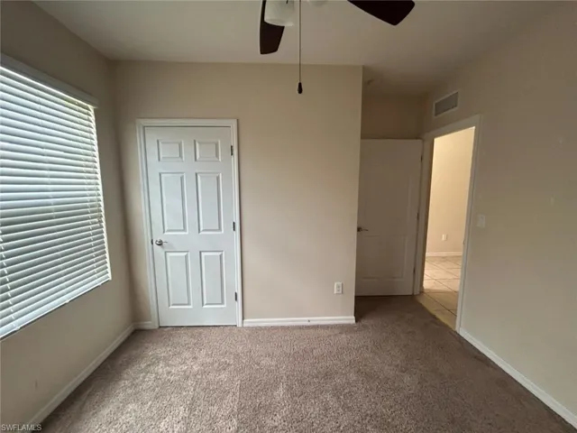 Unfurnished bedroom featuring light colored carpet and ceiling fan