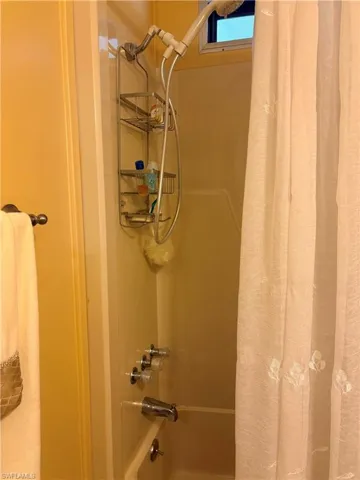 Bathroom view of shower / tub combo with curtain