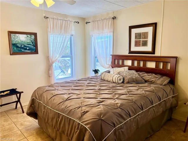 Tiled bedroom featuring baseboards and ceiling fan