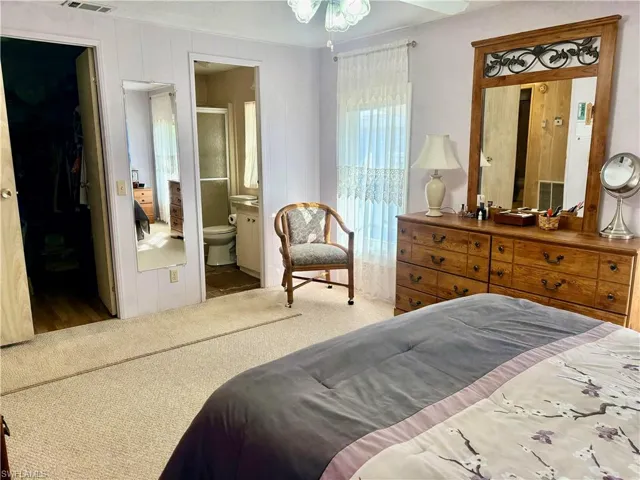 Bedroom with carpet, a spacious closet, and ensuite bathroom