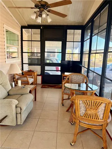 Sunroom / solarium with a ceiling fan, tile patterned floors, and wooden ceiling