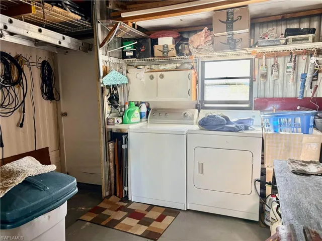 Laundry area with finished concrete flooring and separate washer and dryer