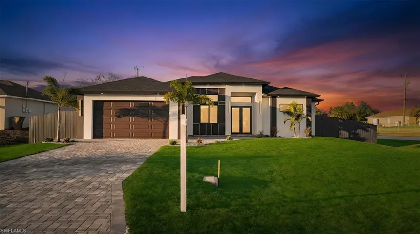 View of front of house with decorative driveway, stucco siding, a garage, and a shingled roof