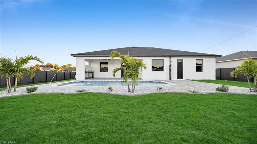 View of swimming pool with patio surround and a fenced backyard